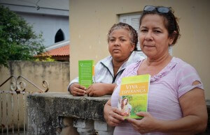 Roseli Pedroso (no primeiro plano) viu o livro pela TV Novo Tempo e ficou surpresa ao receber um exemplar através dos voluntários que realizaram a campanha na cidade onde mora. Foto: Márcio Tonetti