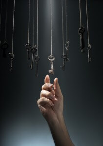 Hand choosing a hanging key amongst other ones.